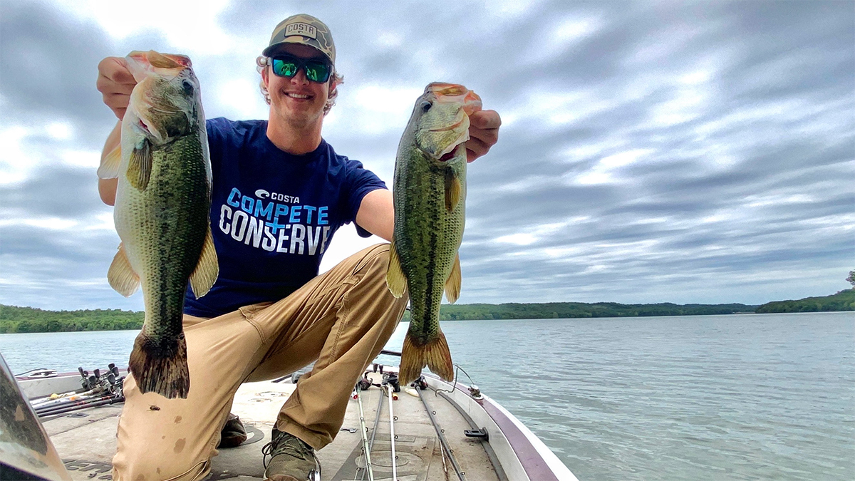 angler holding two largemouth bass